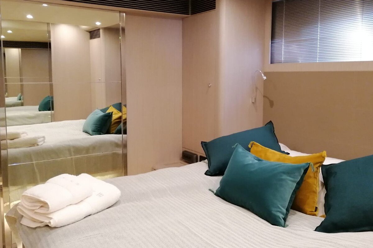 A bedroom with two beds and a mirror