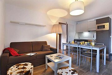 A living room with a brown couch and a white table