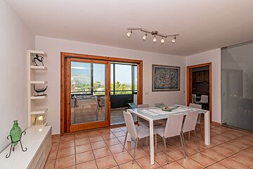 A dining room with a table and chairs and a sliding glass door