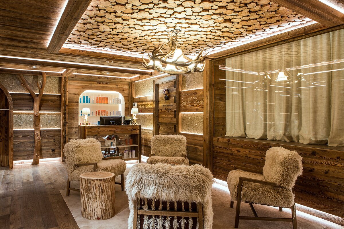 A room with a ceiling made of logs and furry chairs