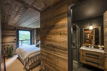 A bedroom with a bed and a bathroom with a sink