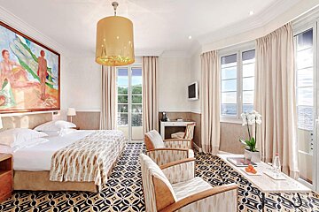 A hotel room with a large painting on the wall above the bed