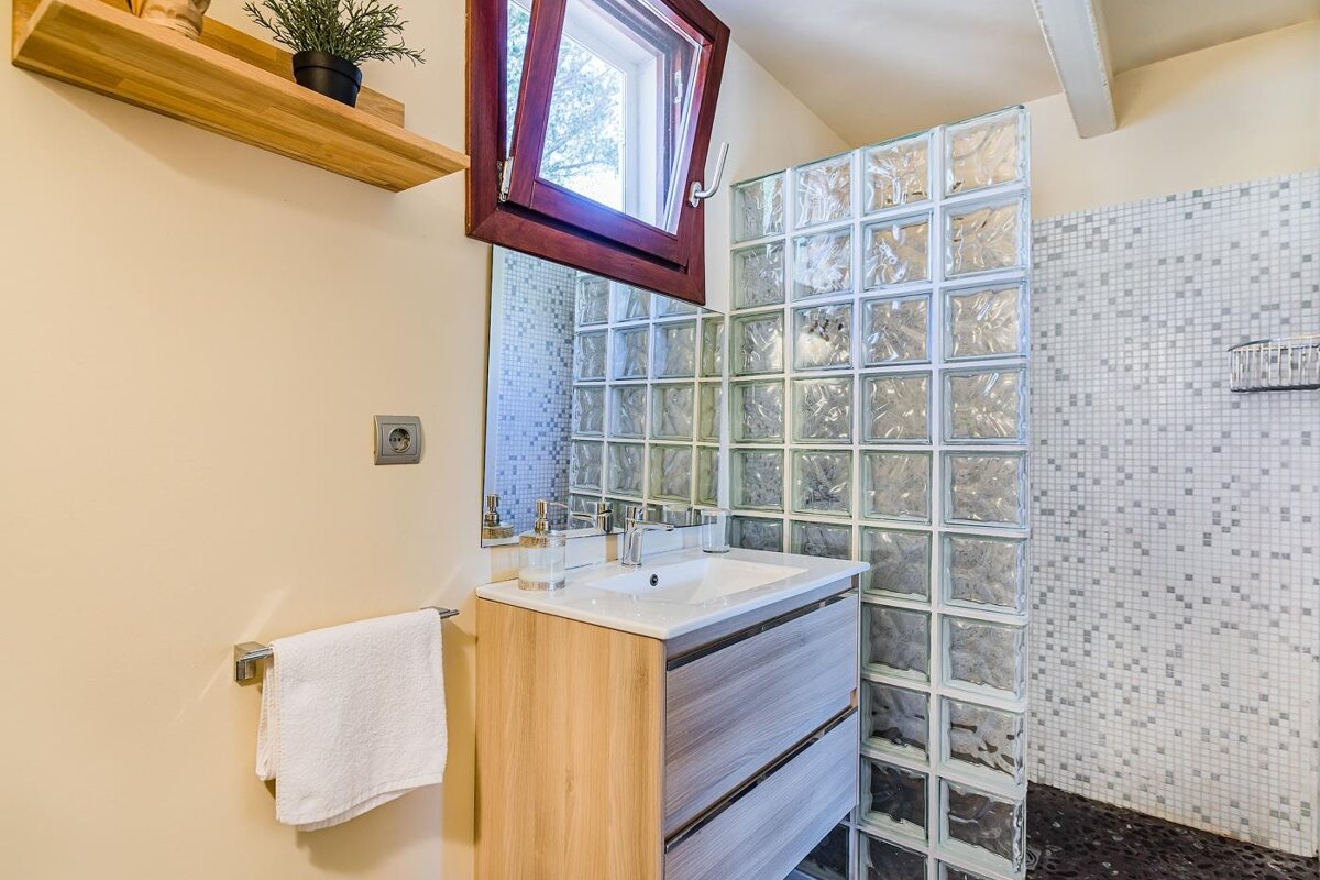 A bathroom with a sink a mirror and a window