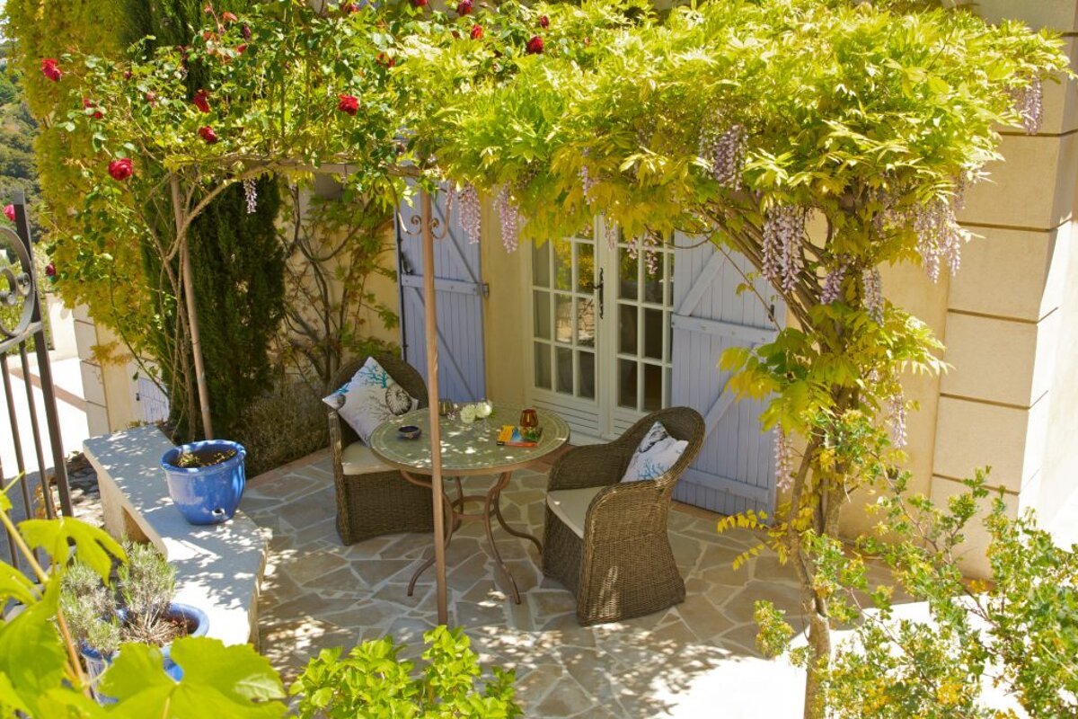 A patio with a table and chairs under a pergola