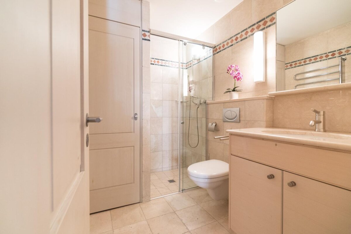 A bathroom with a toilet a sink and a shower