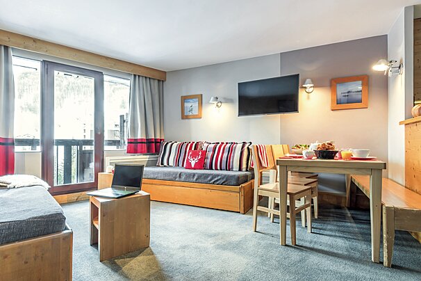 A living room with a couch a table and a flat screen tv