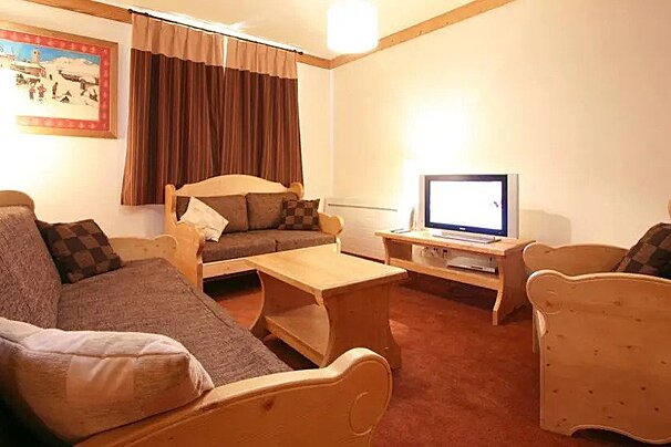 A living room with wooden furniture and a flat screen tv