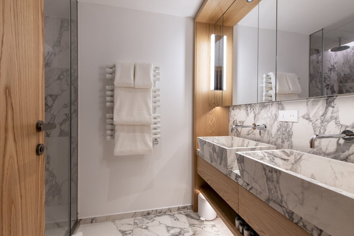 A bathroom with two sinks and a towel rack