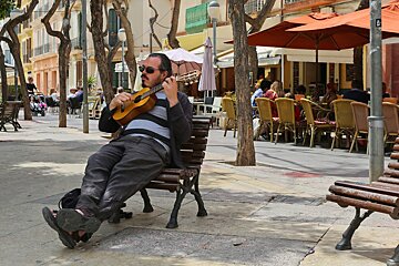guy playing small guitar in ibiza town