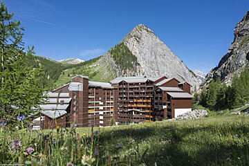 A large building with a mountain in the background