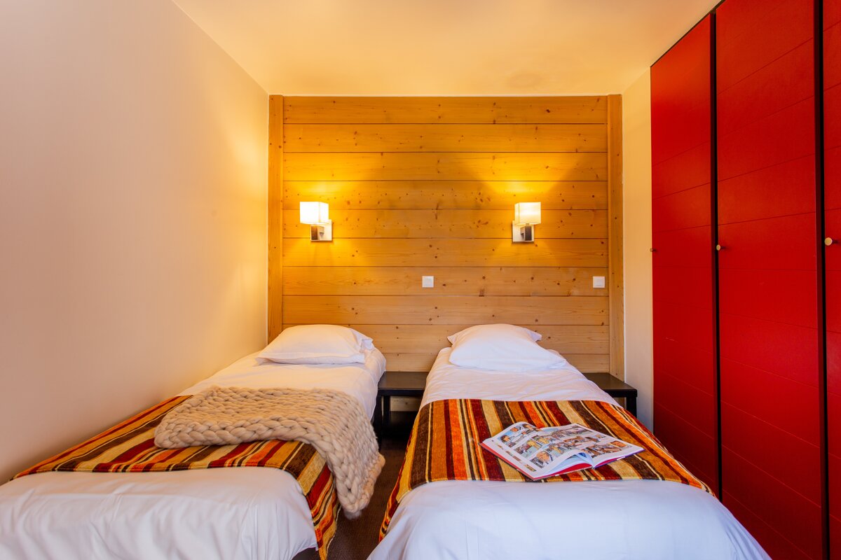 A bedroom with two beds and a book on the bed