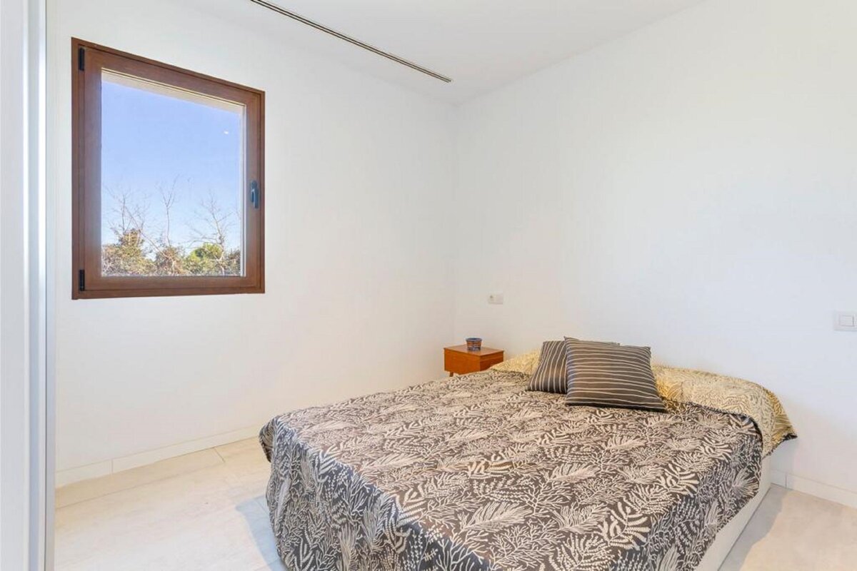 A bedroom with a large bed and a window