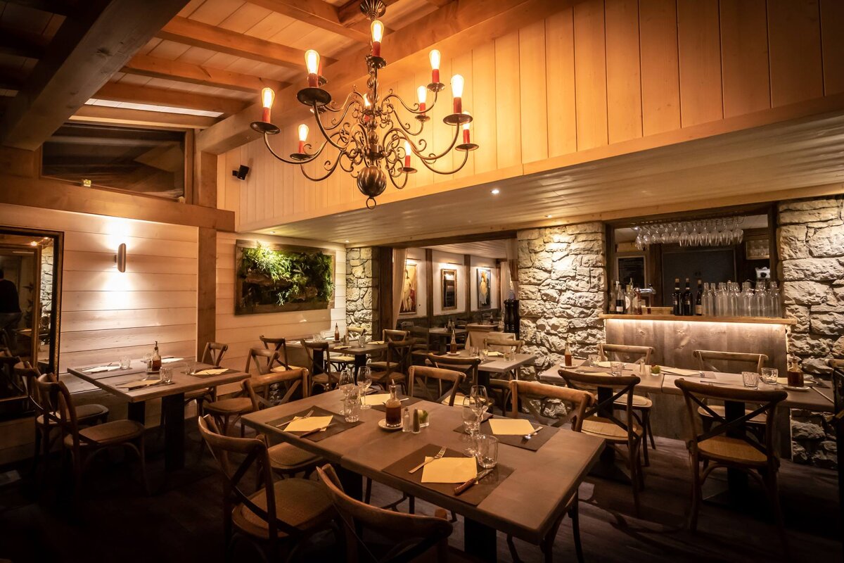 A dining room with tables and chairs and a chandelier