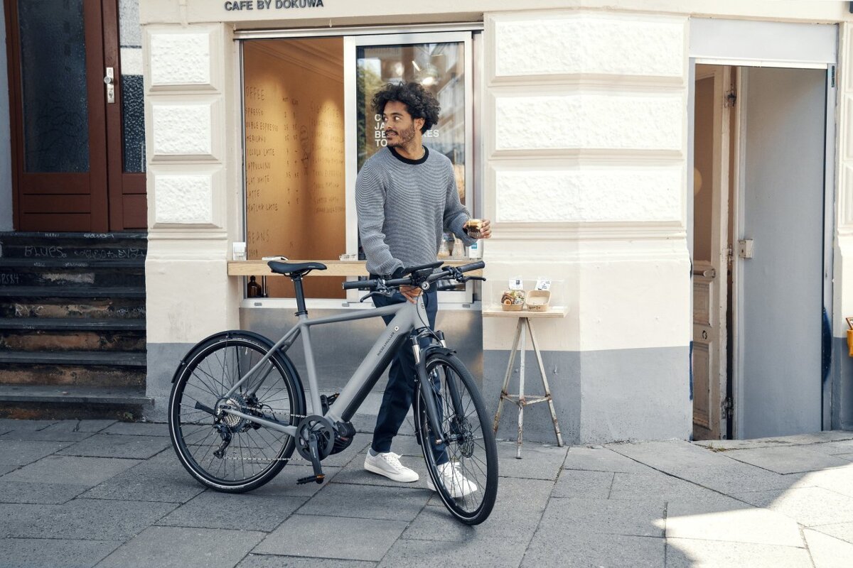 A man with a bicycle in front of a cafe by dokuma