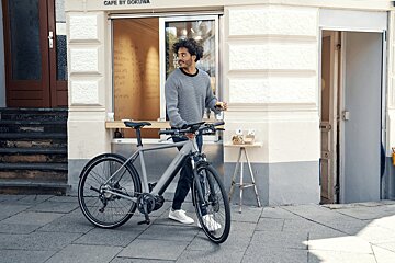 A man with a bicycle in front of a cafe by dokuma