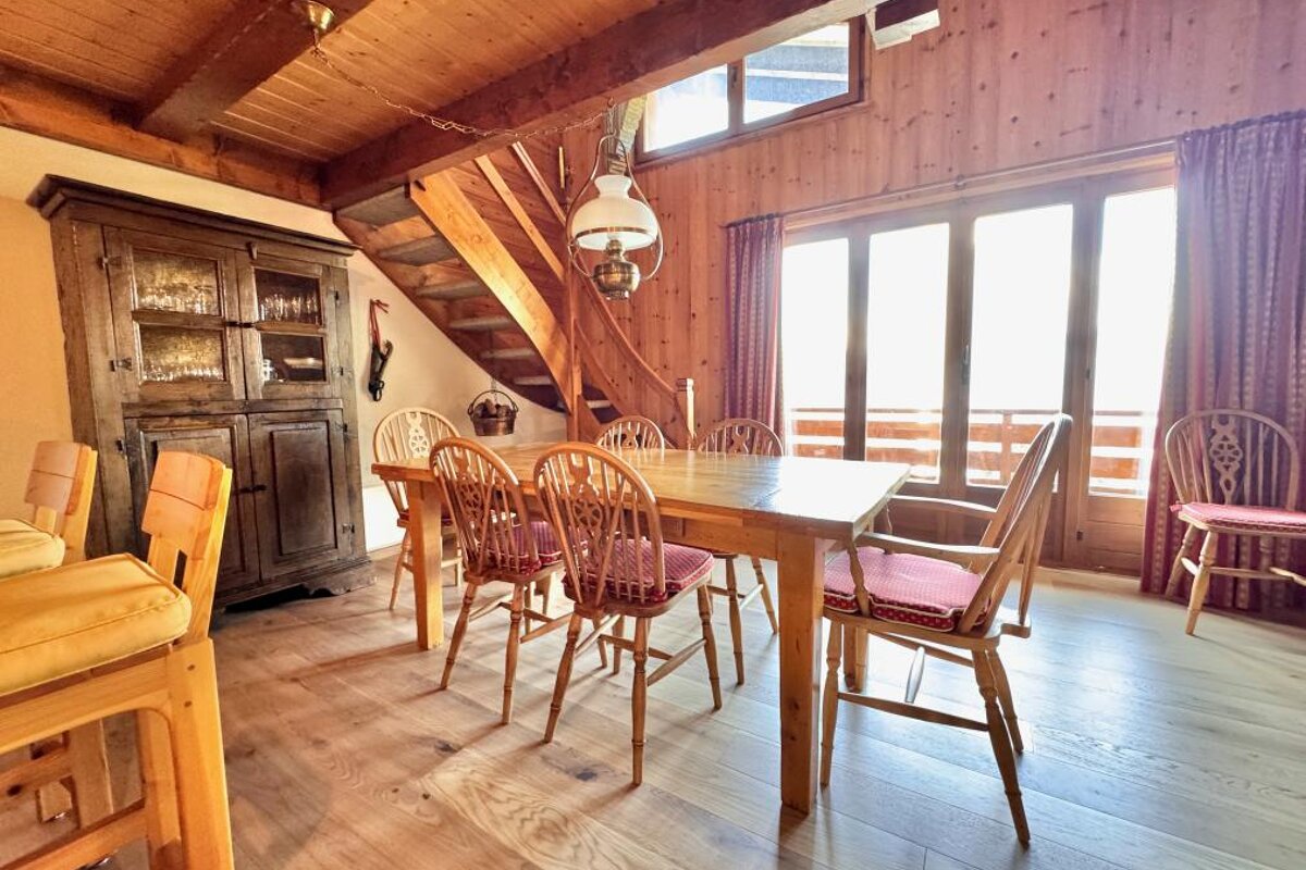 A wooden dining room with a table and chairs