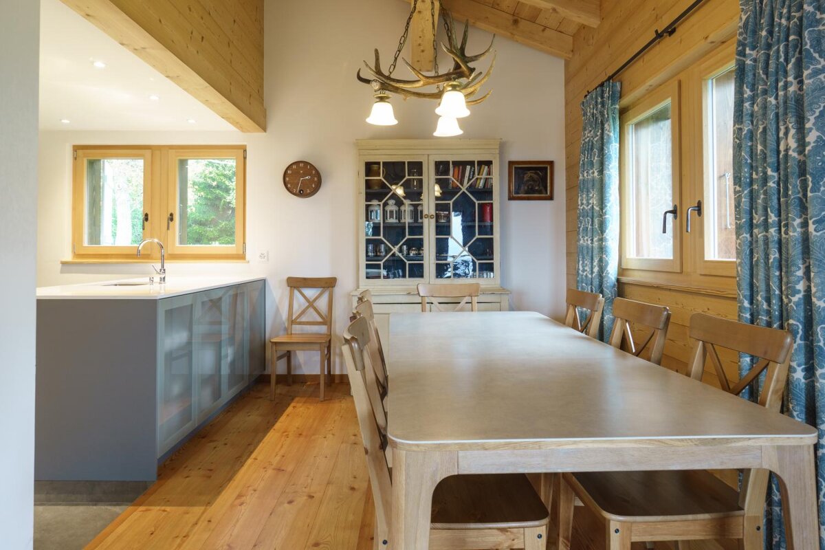 A kitchen with a table and chairs and a clock on the wall