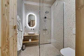 A bathroom with a walk in shower and a sink