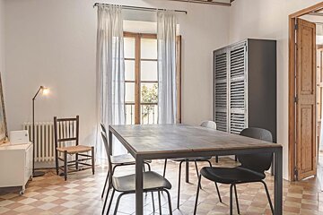 A room with a table and chairs and a window