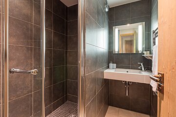 A bathroom with a sink and a walk in shower