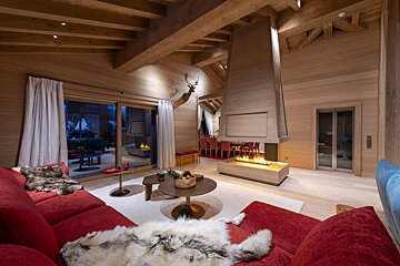 A living room with red furniture and a fireplace