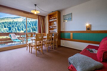 A living room with a table and chairs and a balcony