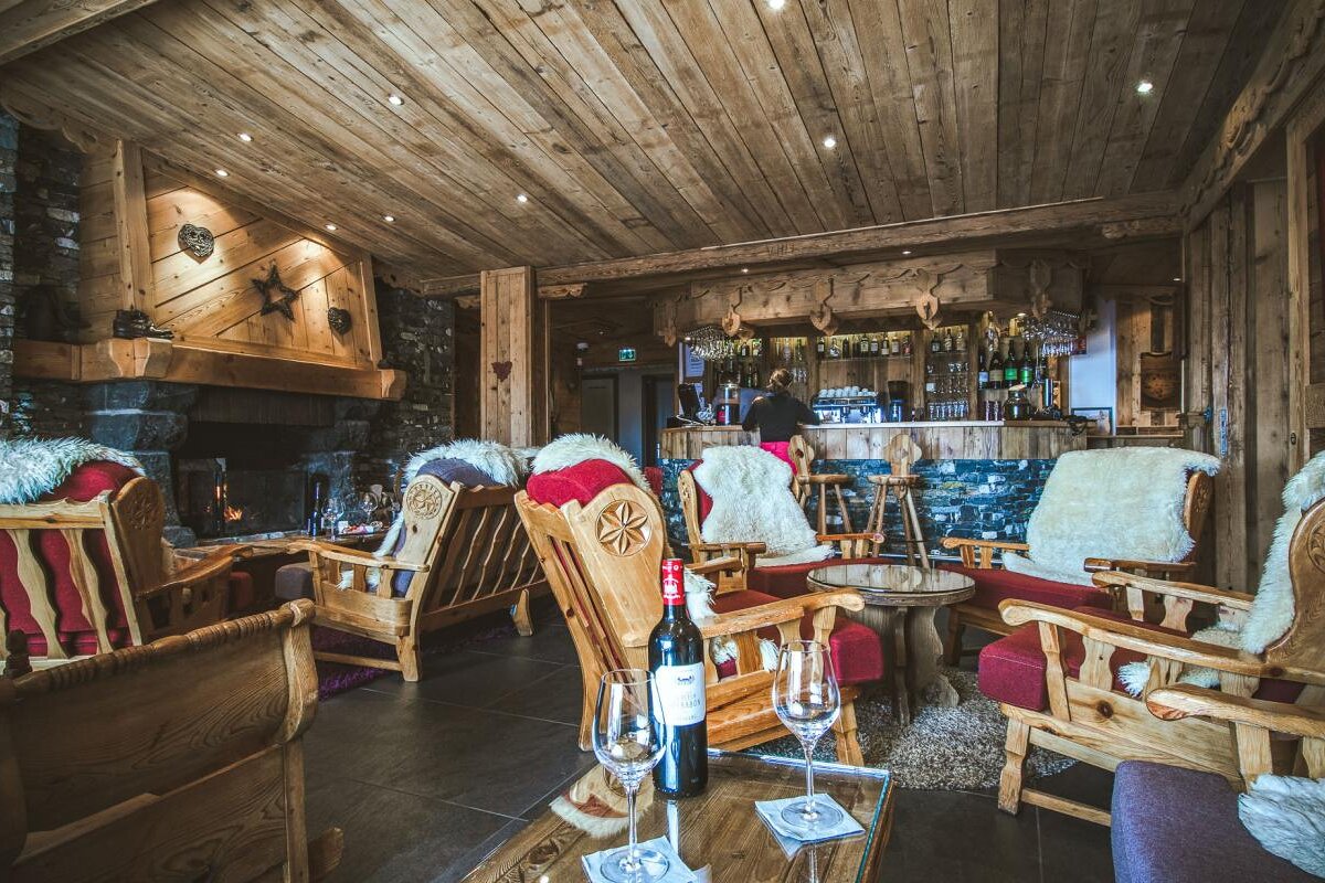 A bottle of wine sits on a table in front of a bar