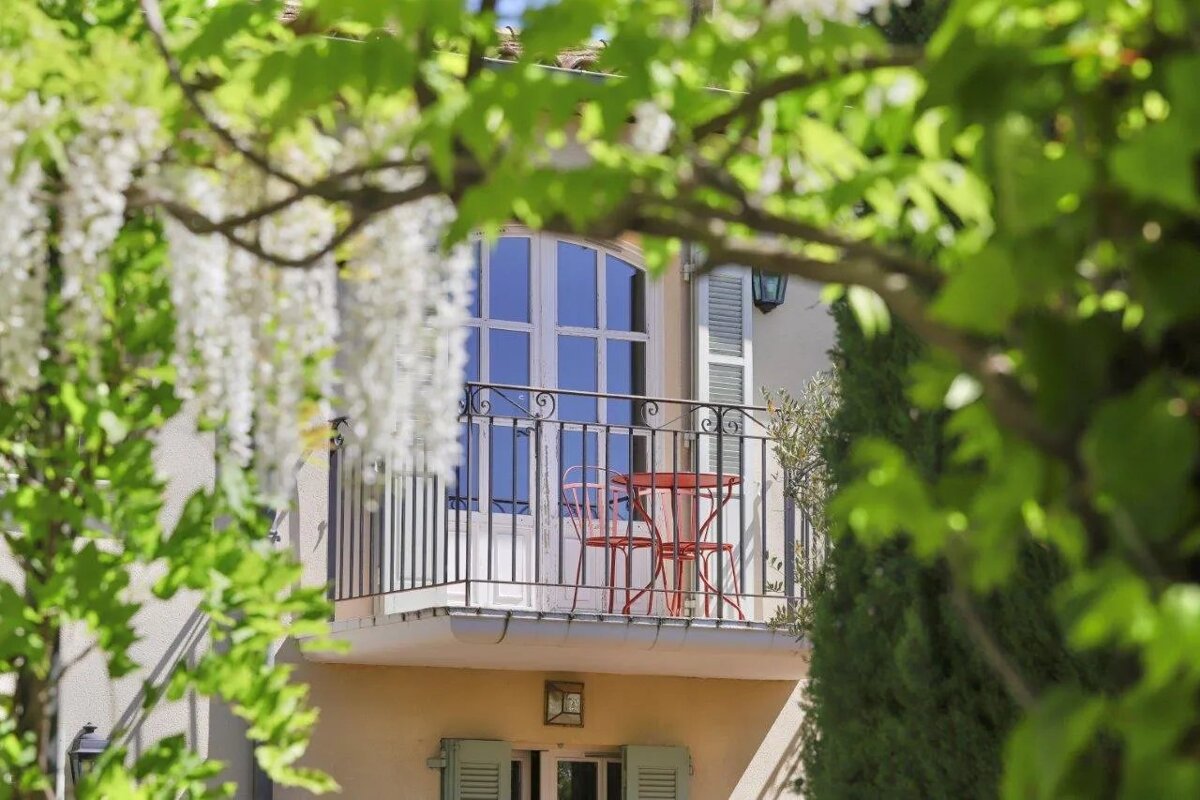 A balcony with a table and chairs surrounded by trees