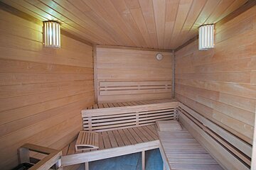 A wooden sauna with a light on the ceiling
