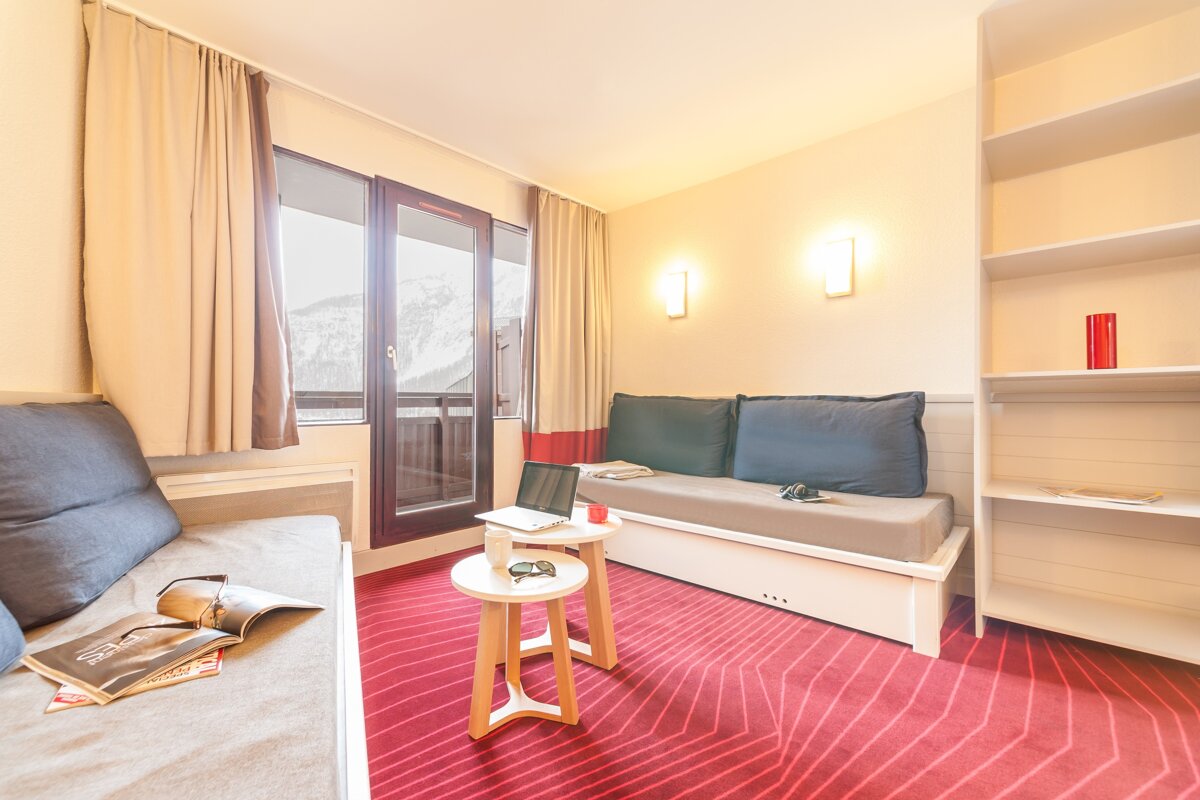 A living room with a couch and two small tables