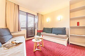 A living room with a couch and two small tables