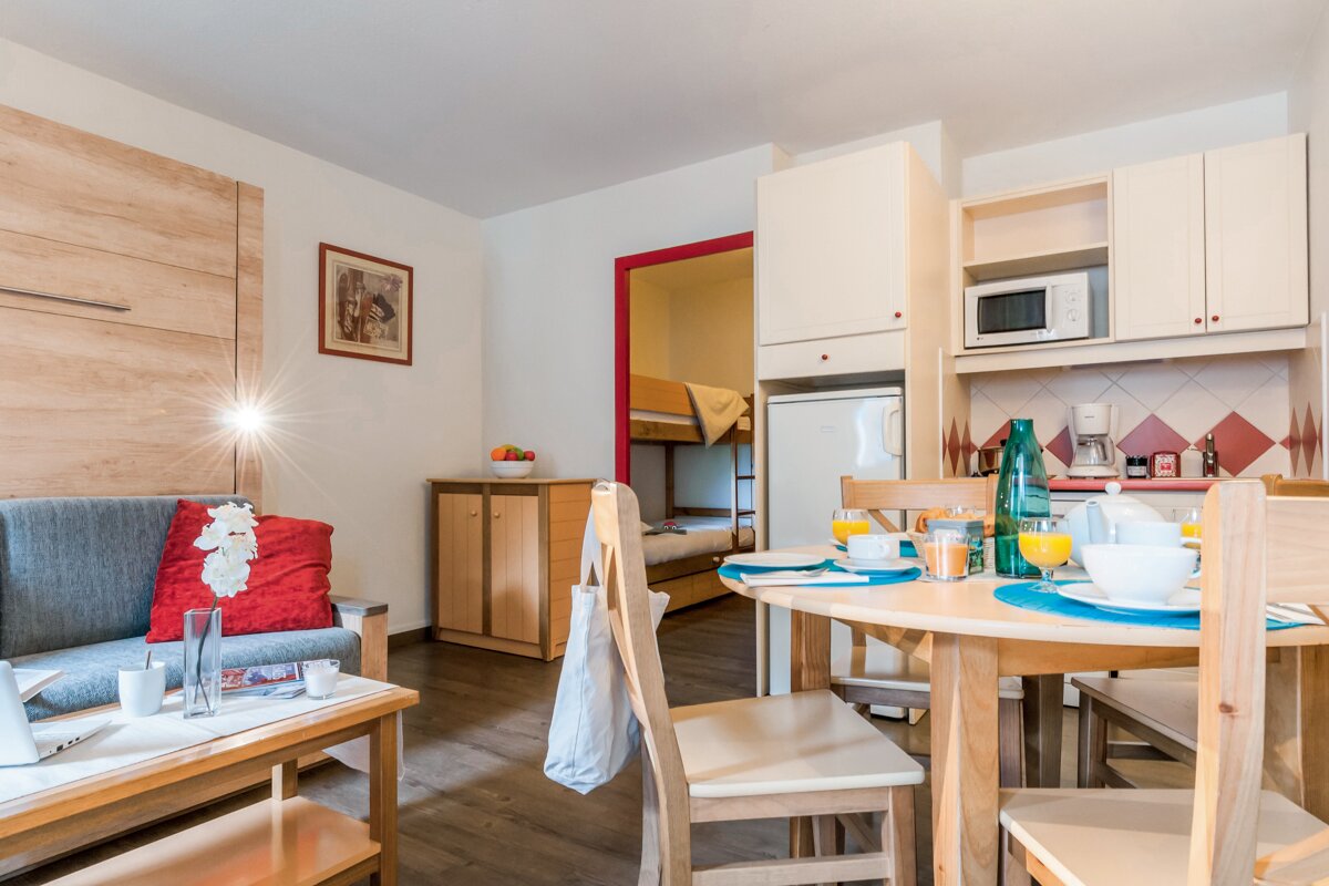 A living room with a couch and a table and chairs