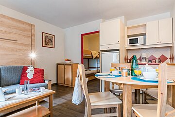 A living room with a couch and a table and chairs