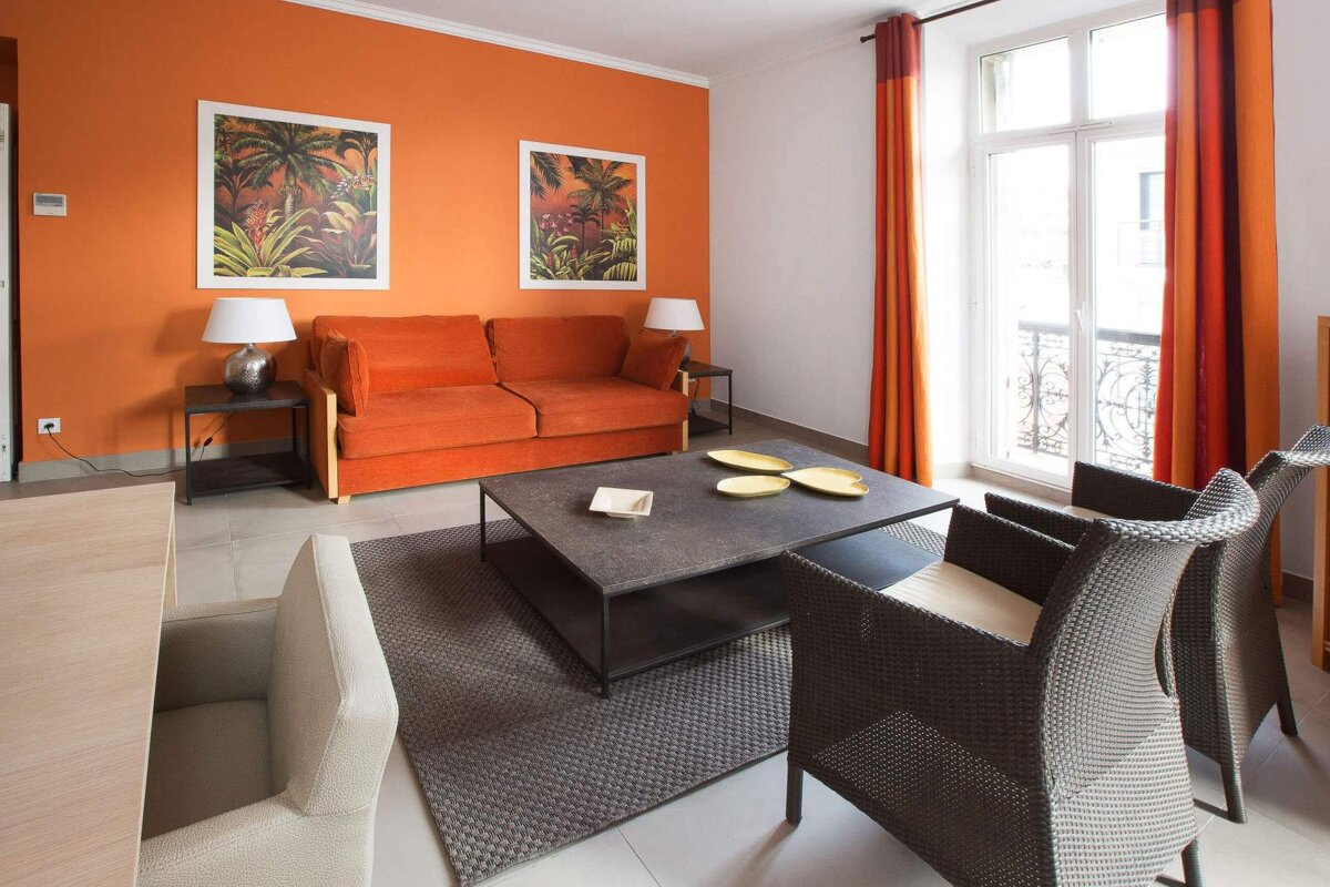 A living room with orange walls and a couch