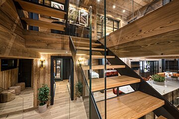 A wooden staircase with a glass railing in a house