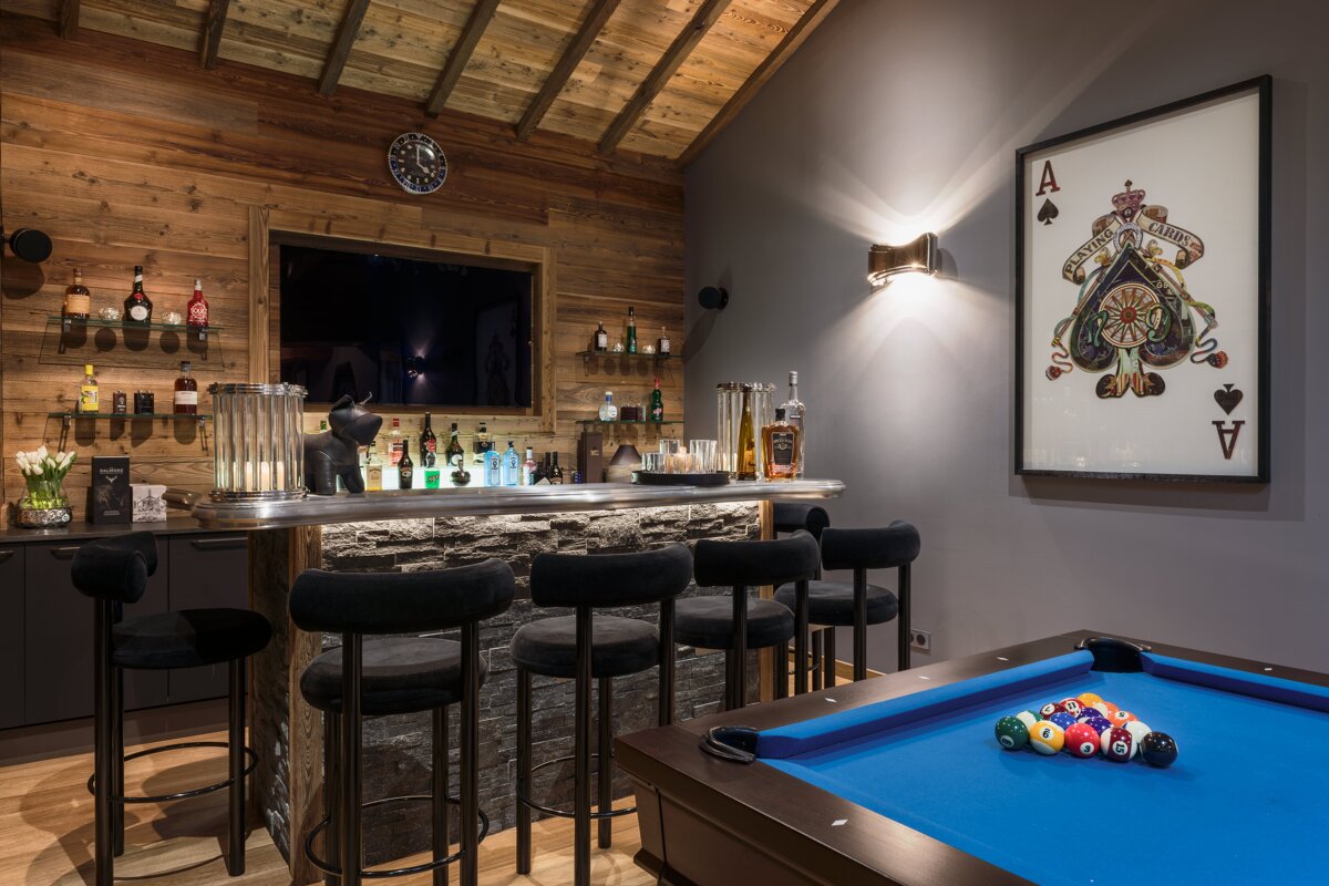 A game room with a pool table and a bar