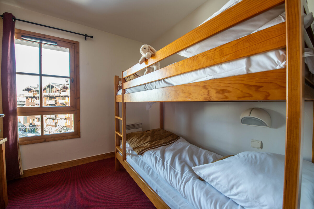 A bunk bed with a stuffed animal on top of it
