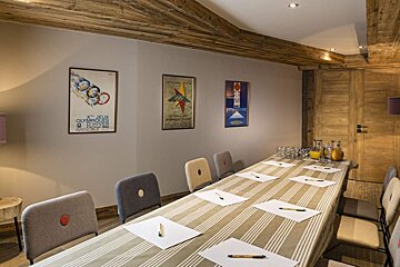 A room with a long table and chairs and a poster on the wall that says 