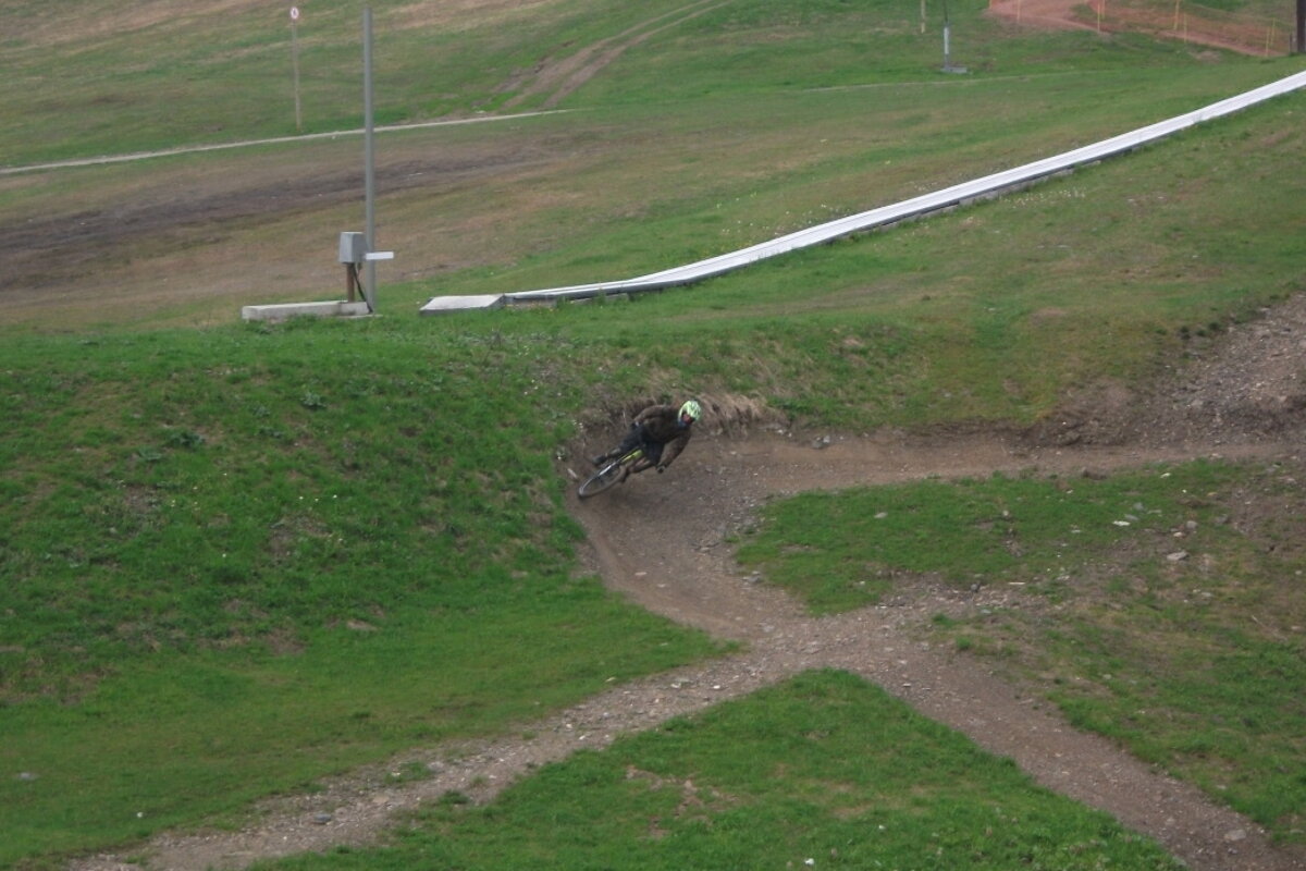A person riding a bike down a grassy hill