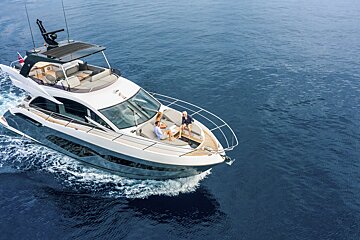 A couple sits on the back of a boat in the ocean