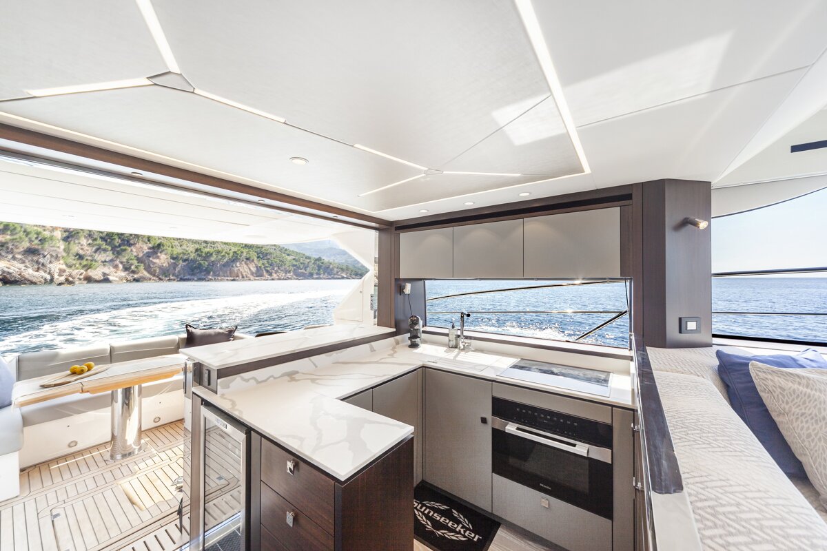 A kitchen on a boat with a rug that says ' alpenschenker ' on it