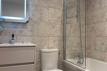 A bathroom with a toilet a sink and a bathtub