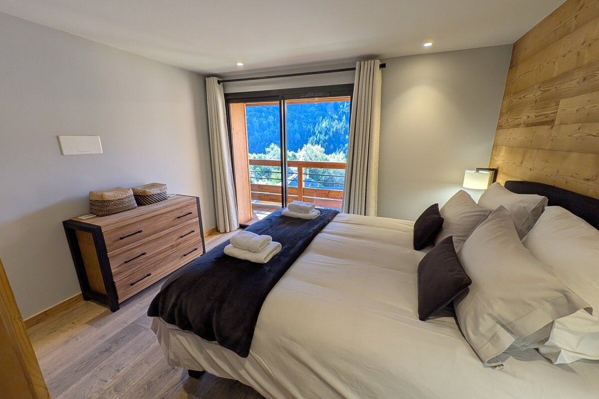 A bedroom with a large bed and a dresser