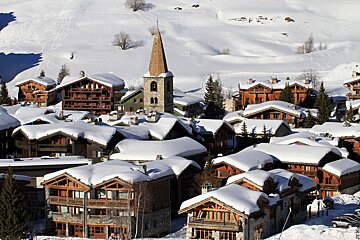 A snow covered village with a church in the middle