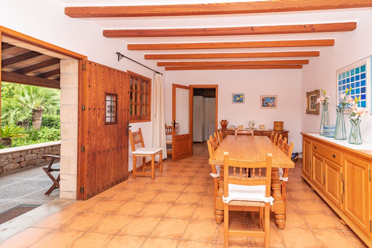 A dining room with a long wooden table and chairs