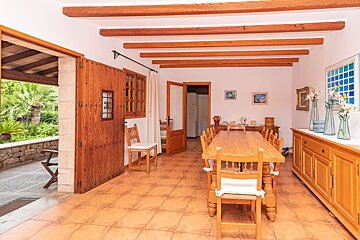 A dining room with a long wooden table and chairs