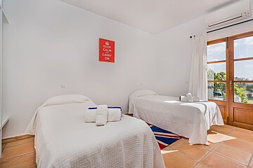 A bedroom with two beds and a sign that says keep calm and carry on