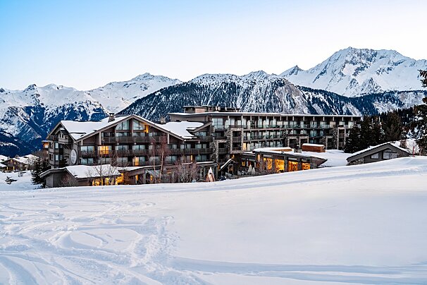 A snowy mountain with a large building in the foreground