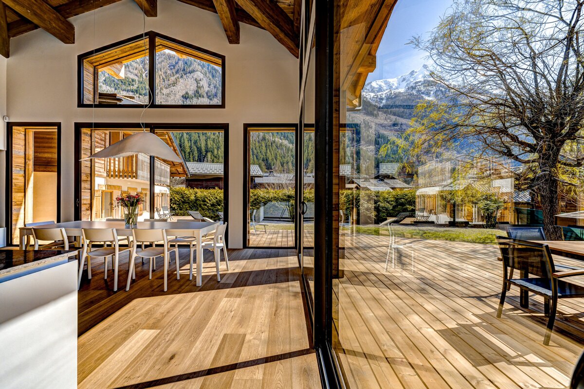 A dining room with a table and chairs and a view of the mountains