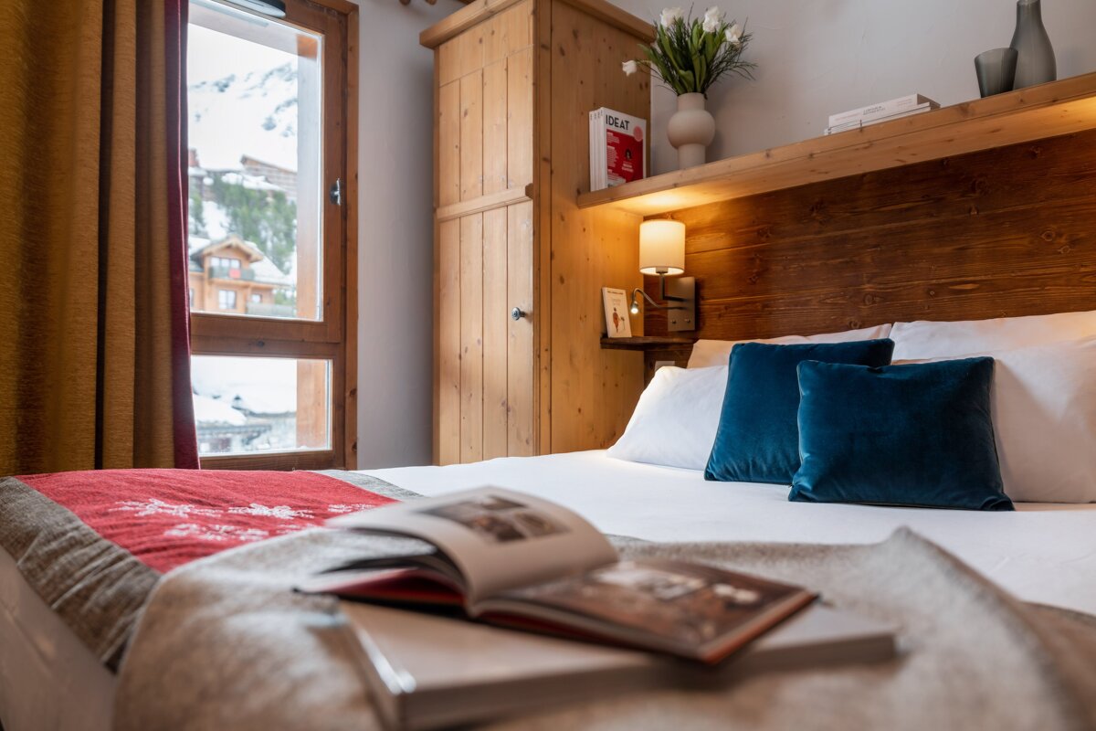 A book titled great sits on a shelf above a bed